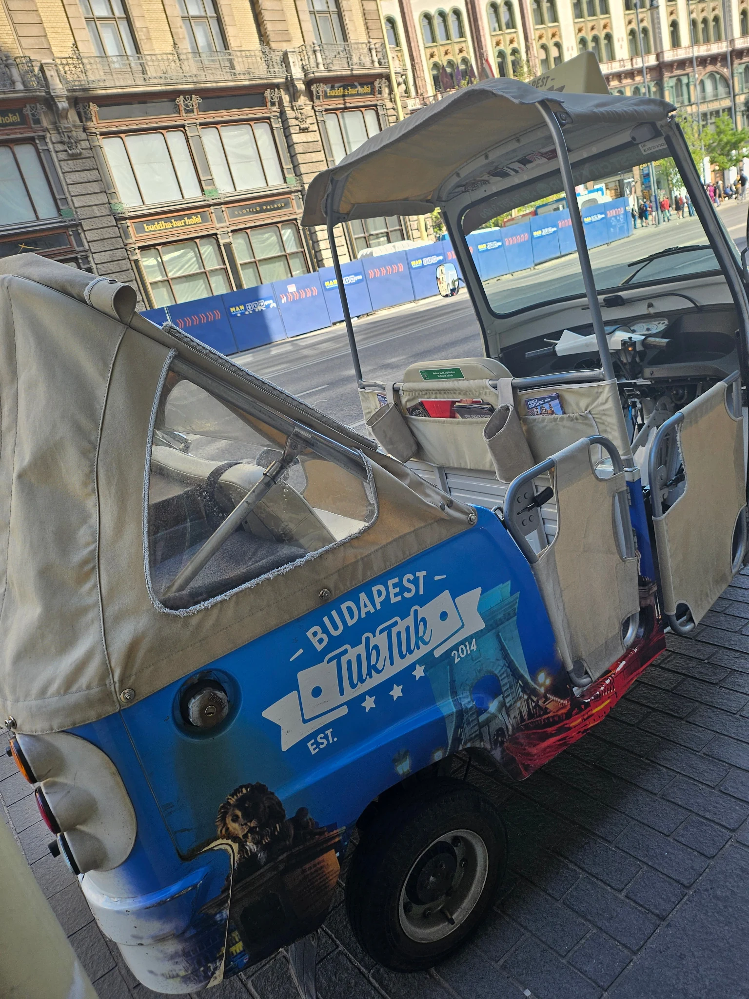 Our blue Budapest TukTuk parked on a city street.