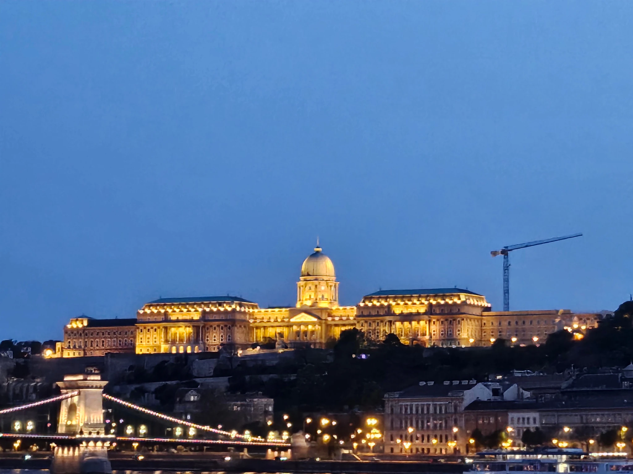 Buda Castle glowing above the Danube at blue hour.