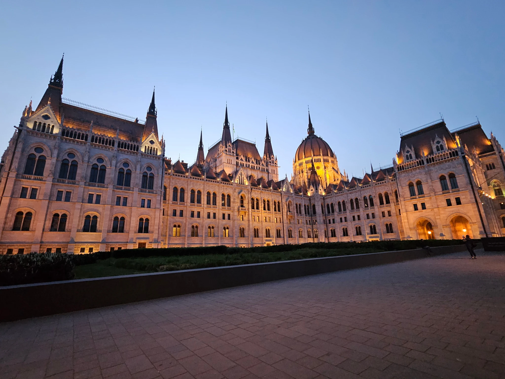 The ornate Hungarian Parliament building beneath a blue evening sky.