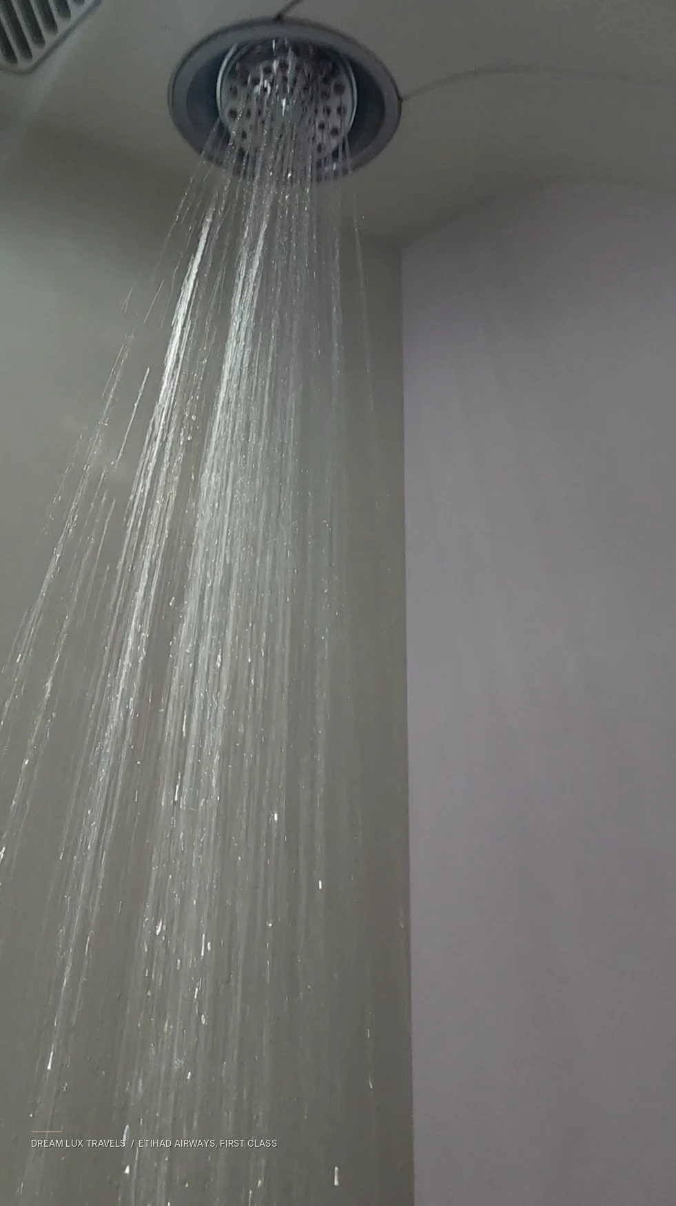 Water streaming from the operating shower head onboard Etihad First Class.