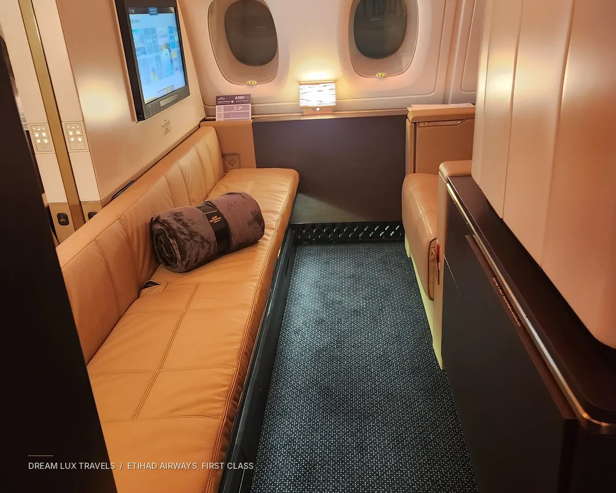 Private First Class aircraft suite with warm cream upholstery and windows.