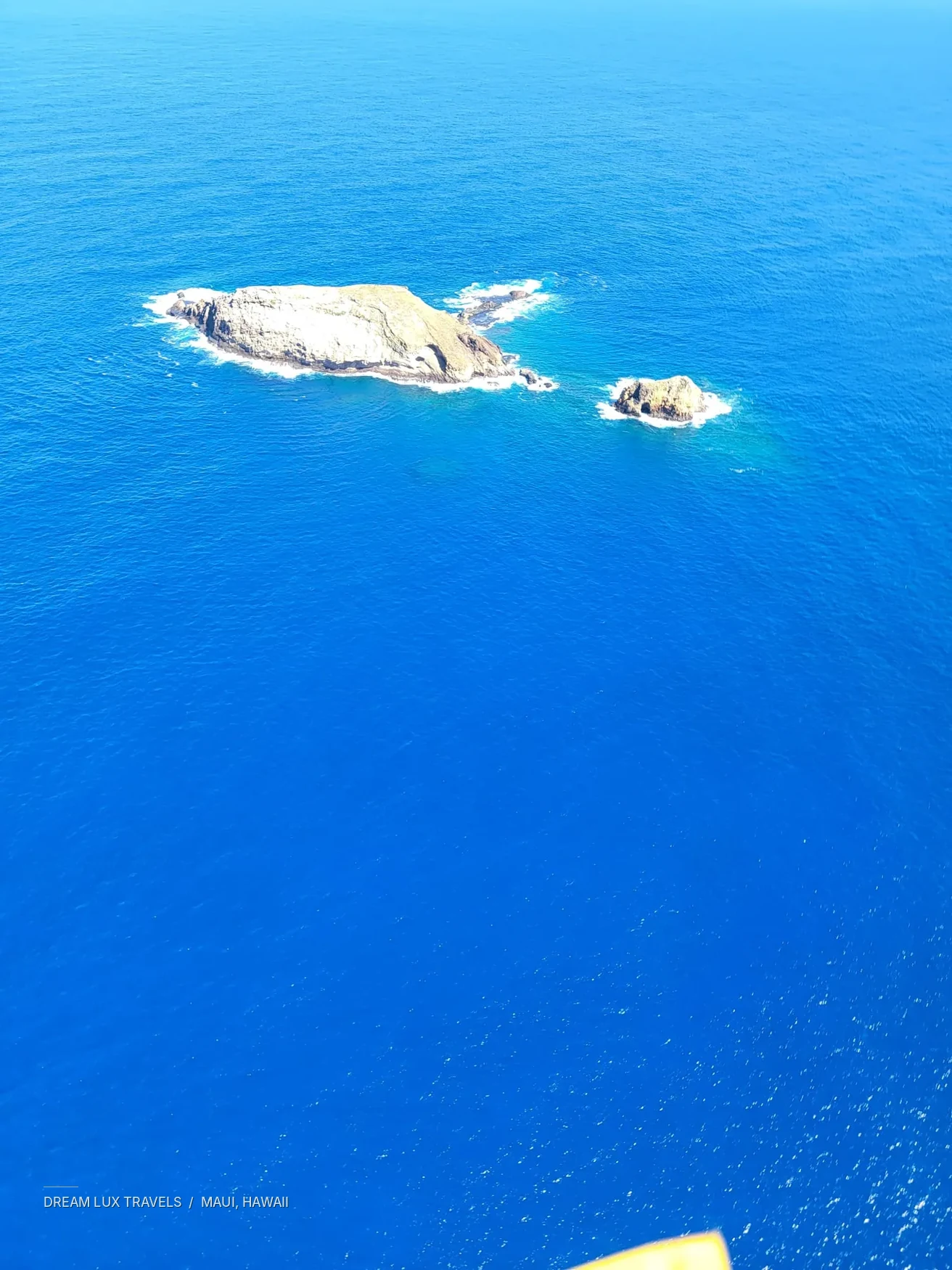 Islets surrounded by blue ocean, viewed during the Maui helicopter tour.