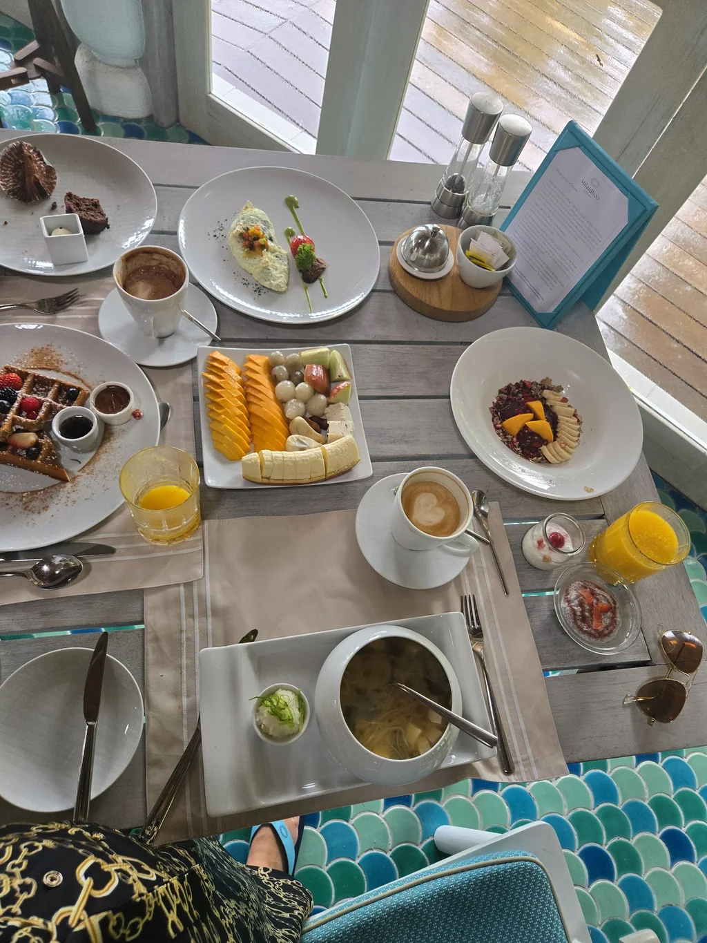 An assortment of breakfast dishes on a table beside the water at Milaidhoo Maldives.