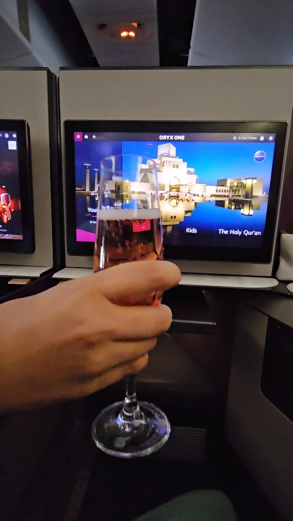 Qatar Airways Qsuite personal entertainment screen and adjacent cabin space photographed in November 2023.